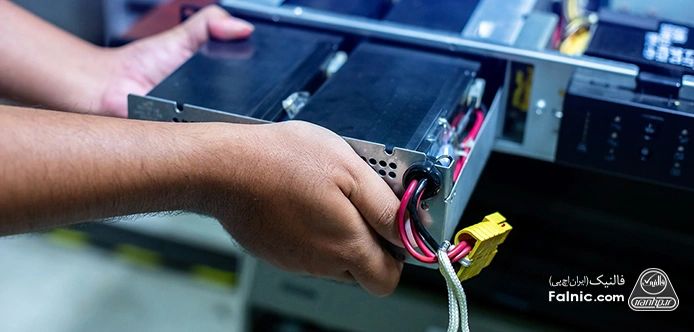 دستان یک مرد در حال تعویض باتری یک UPS دستان یک مرد در حال تعویض باتری یک UPS